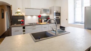 A modern kitchen with a central island, stainless steel appliances, and a pendant light. - Charming Country House in Tourtoirac, Pets Allowed (Tourtoirac)