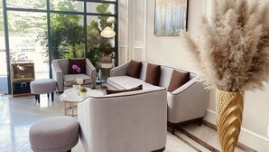 A modern living room with two sofas, a coffee table, and a decorative vase. - Hera Luxury Hotel (Ho Chi Minh City)
