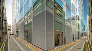 A modern building with large glass windows and a metal facade.