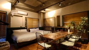 A hotel room with two beds, a wooden dining table, chairs, and potted plants. - sunmalldai3 (Tokyo)