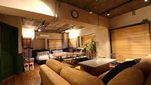 A modern living room with a sofa, a dining table, and a clock on the wall. - sunmalldai3 (Tokyo)