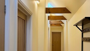 Un corridoio con porte in legno e un appendiabiti a parete.