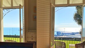 A room with a view of the sea, a wicker chair, and a small table. - Recently refurbished and sleeping up to 4 guests, this stylish apartment offers stunning sea views, modern interiors, a fully equipped kitchen and a prime central location. Just moments from Ramsgate's Royal Harbour, beach, cafés and restaurants. (Kent)