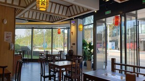A restaurant interior with wooden furniture, large windows, and traditional lanterns.