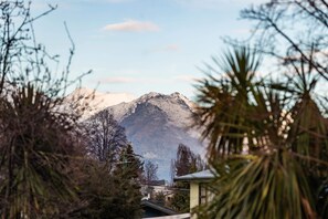 A mountain with a clear sky, surrounded by trees and buildings.