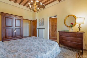 Ein Schlafzimmer mit Bett, Schminktisch und einer Kronleuchter.
