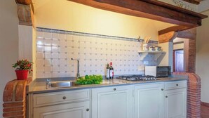 A kitchen with a tiled backsplash, a gas stove, and a sink. - PYRUS - First floor apartment 75 m2 (Montaione)