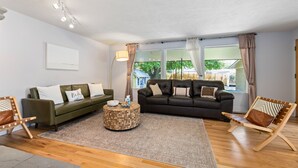 A living room with two sofas, a coffee table, and a chair.