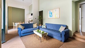 A modern living room with a blue sofa, a coffee table with plants, and a painting on the wall. - Maridda sicilian vacation home (Giarre)