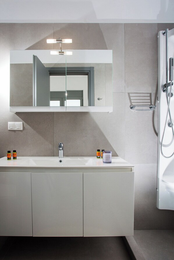 A modern bathroom with a large mirror, two sinks, a shower, and a towel rack. - Villa Klelia, a Newly Built 2023 Villa With Private Pool Next to Kissamos (Kissamos)