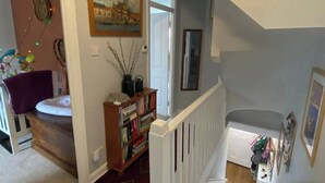 A staircase with a white railing leading to a landing. A bookshelf with various items is placed on the landing. - Spacious & Central 2BD House - Brighton (Brighton)