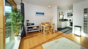 Un apartamento moderno con comedor, cocina y un amplio ventanal con vistas.