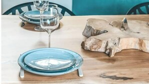 A dining area with a wooden table, blue plates, and wine glasses. - Villa La Nîmoise (Nîmes)
