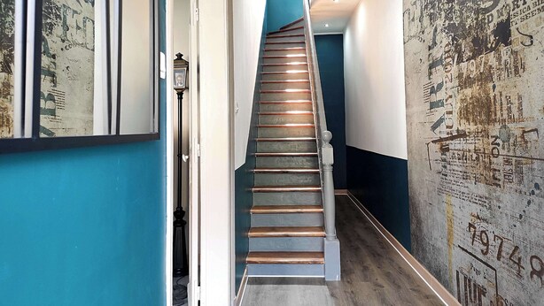 A narrow hallway with a wooden staircase leading to a landing. - Home for family or business stays (Cambrai)