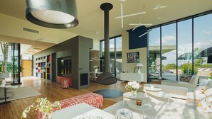Una sala de estar moderna con un amplio ventanal, un sofá, una mesa de centro y una estantería.