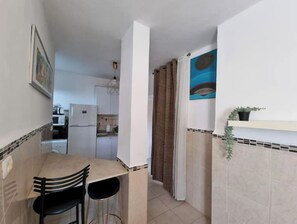 Enjoy meals at the dining table with a kitchenette nearby.