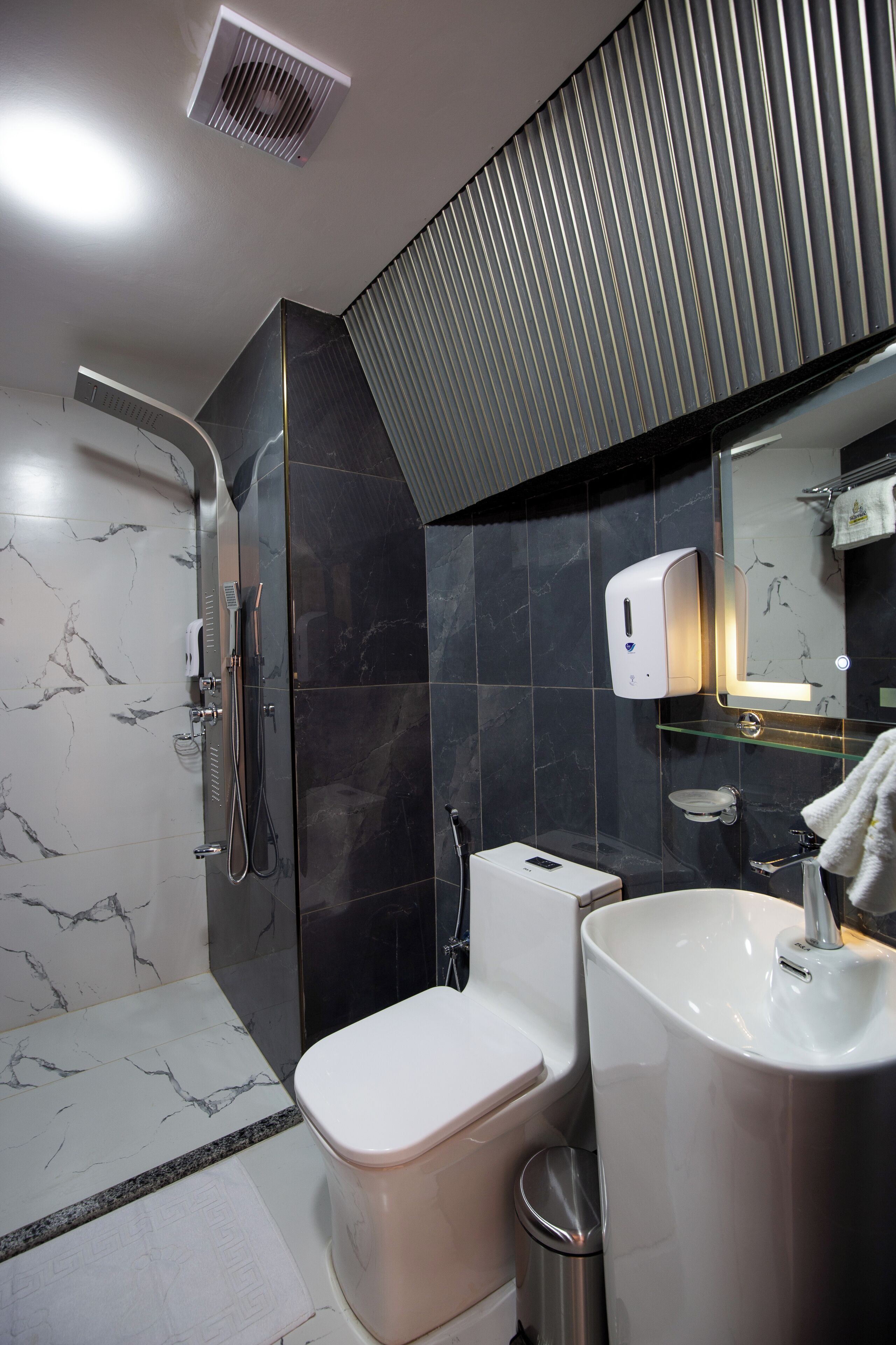 A modern bathroom with a shower, toilet, and sink.