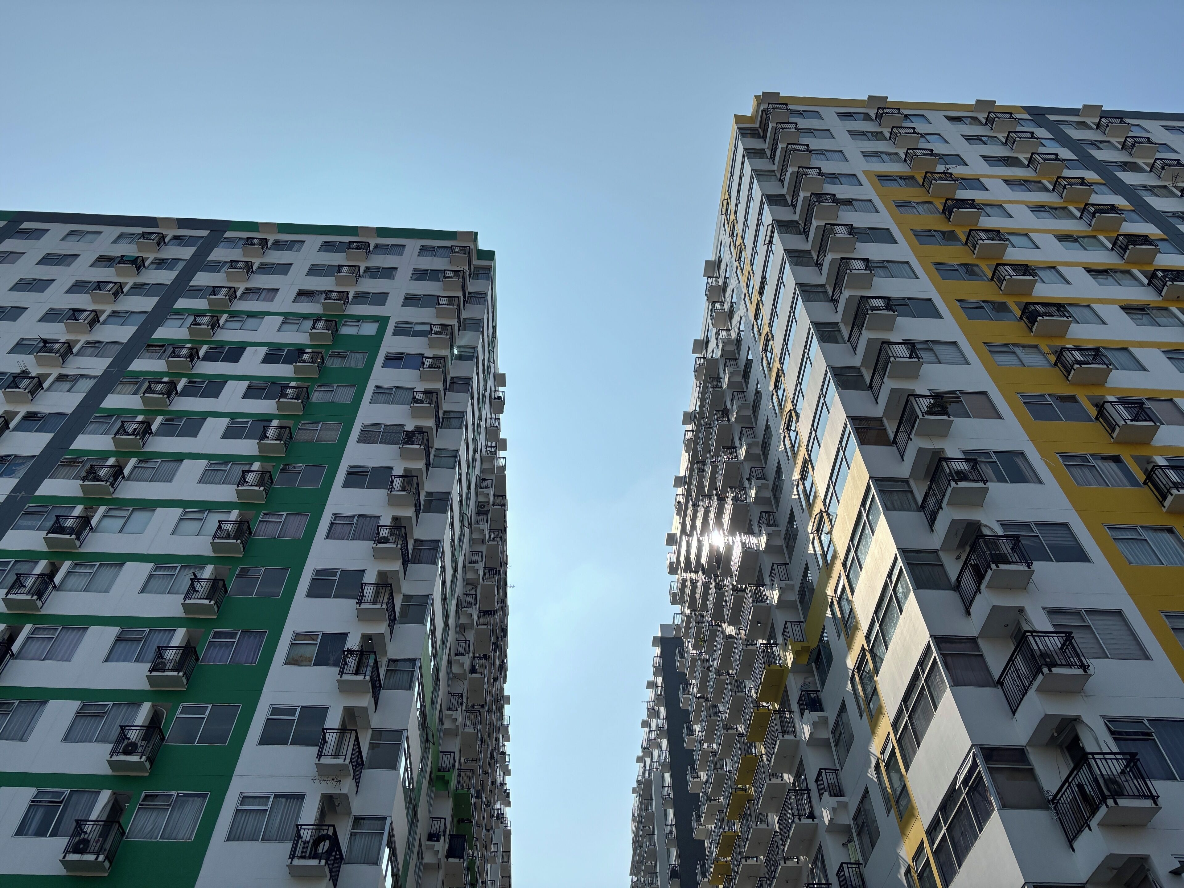 Two high-rise buildings with multiple balconies and air conditioning units.