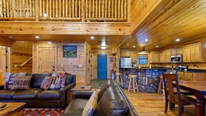 L’intérieur d’une cabane en bois comprend un salon, un coin repas, une cuisine et un escalier.