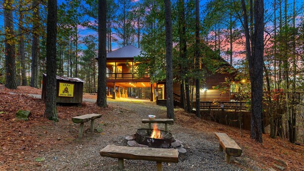 Un chalet doté d’un foyer, de bancs et d’un panneau indiquant l’emplacement prévu pour les feux de camp.