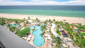 Een resort met een groot zwembad, strand en uitzicht op de oceaan.