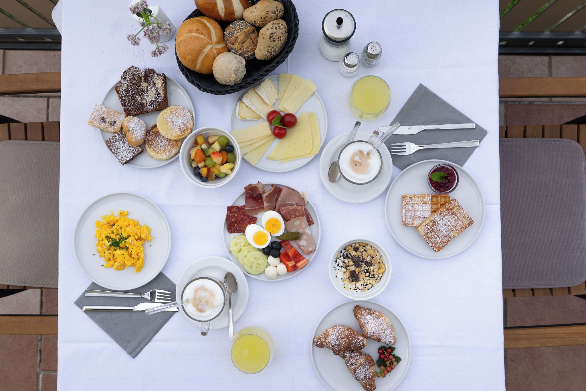 Un buffet della colazione con diversi piatti e posate disposti su un tavolo.