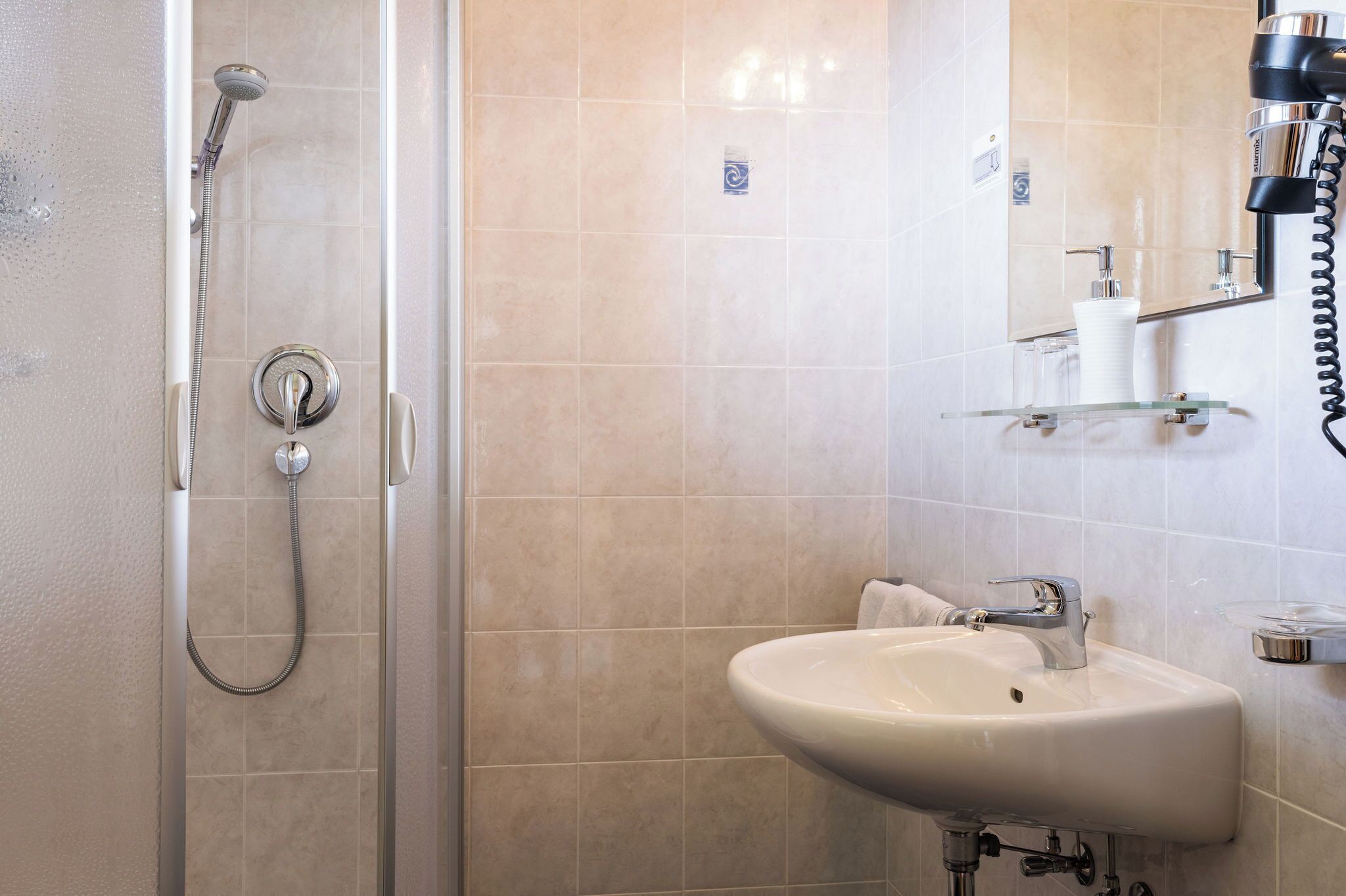A bathroom with a shower, sink, and toilet.