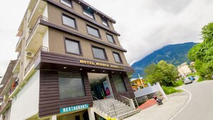 Un edificio de varios pisos con un restaurante en la planta baja y un hotel llamado "Hotel Mirage Residency" en los pisos superiores.