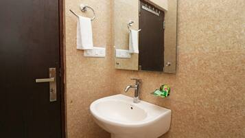 Une salle de bain avec un lavabo, un porte-serviettes et un miroir.