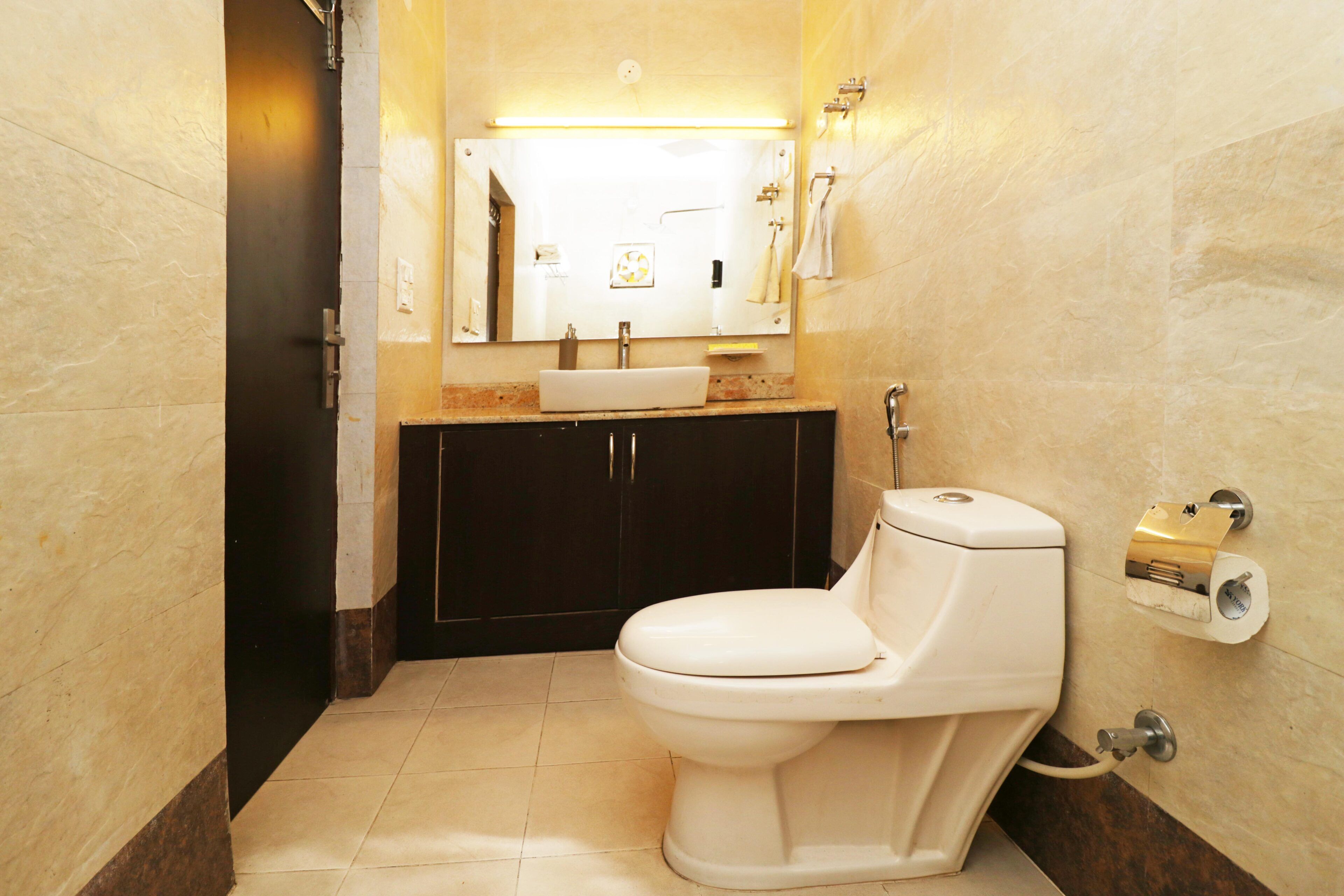A bathroom with a white toilet, a sink, a mirror, and a towel rack.