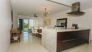 Una cocina moderna con encimera de granito, armarios de madera oscura y una campana extractora de acero inoxidable.