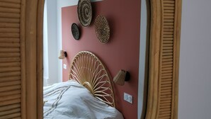 Une chambre à coucher avec un lit, un miroir et des éléments décoratifs sur les murs.