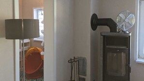 A room with a fireplace, a lamp, a play area, and a basket of firewood. - Double vacation bungalow in the middle of the Schorfheide (Joachimsthal)