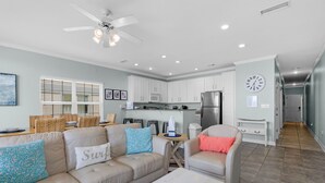 A modern living room with a sofa, coffee table, and a dining area with chairs.