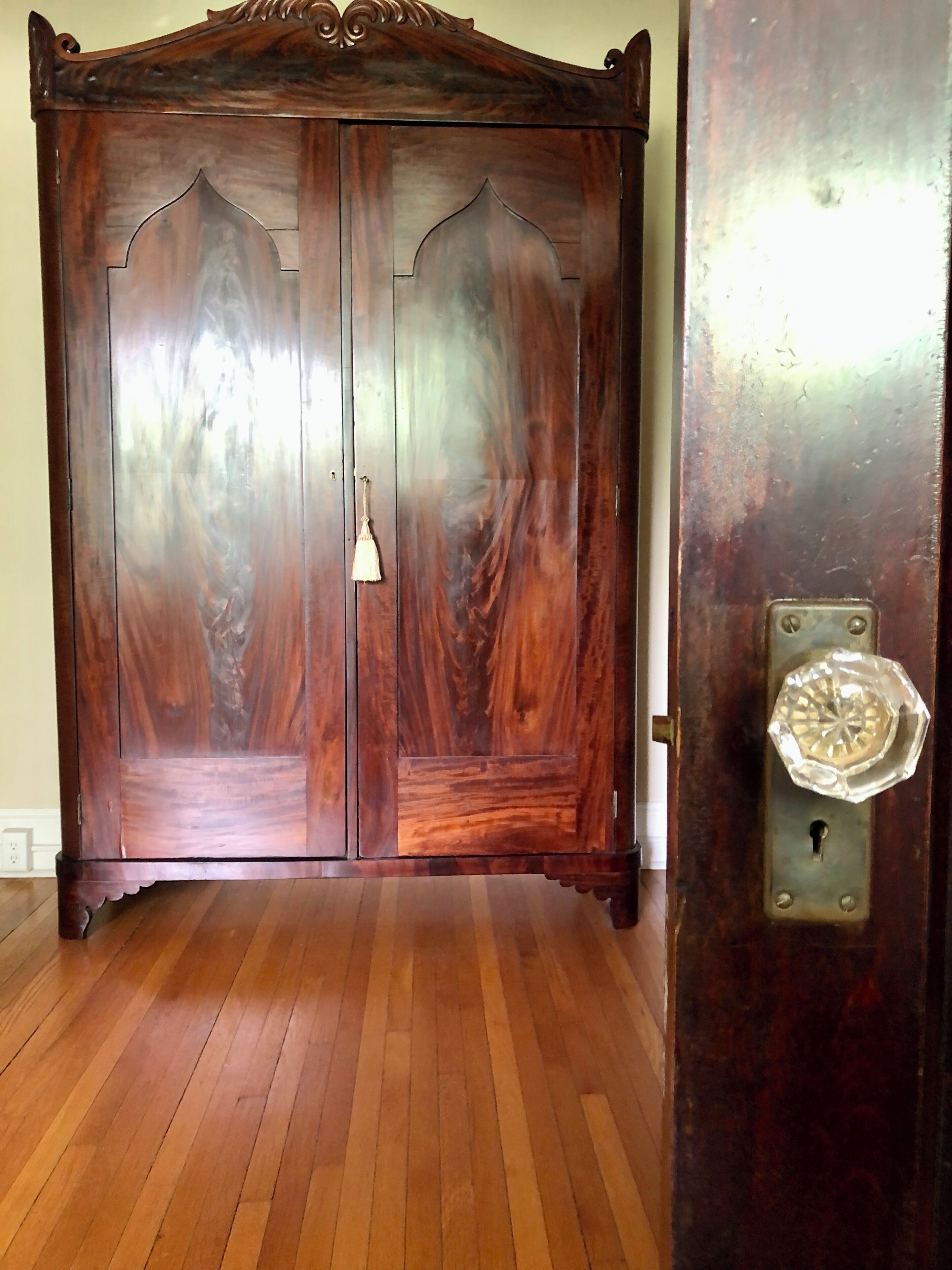 A wooden wardrobe with two doors and a handle.