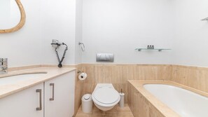 Ein modernes Badezimmer mit Toilette, Bidet und Badewanne.
