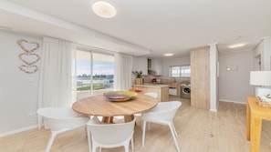 Cozinha moderna com área de jantar, janelas amplas e vista para a cidade.