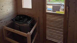 A wooden sauna room with a view of mountains through a window. - La Parenthèse Enchantée (Sevrier)