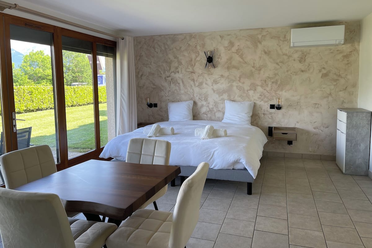 A bedroom with a bed, bedside tables, a desk, and a chair.
