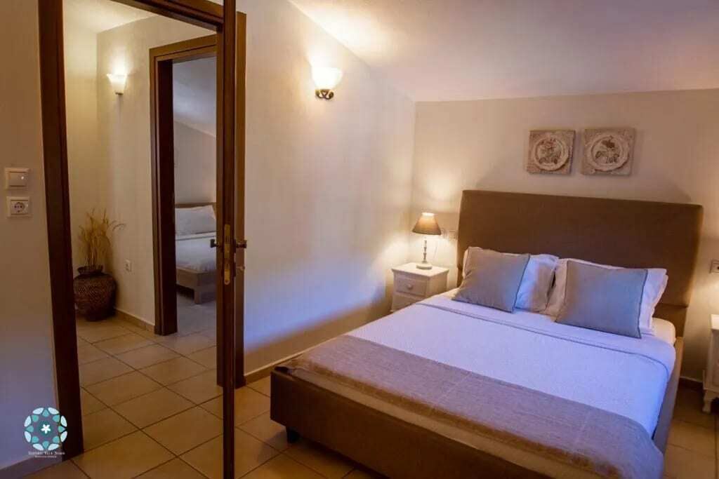 A bedroom with a bed, nightstands, and wall art.