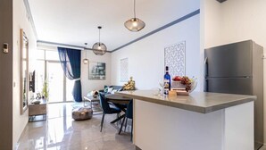 A modern kitchen with a central island, stainless steel appliances, and pendant lighting.