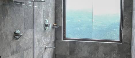 A modern bathroom with a large window, a shower, and a toilet.