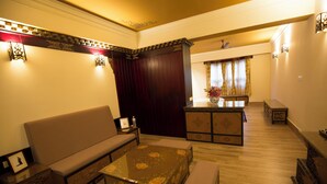 A living room with a sofa, coffee table, and a small dining area with a table and chairs. - Amritara Hidden Land, Gangtok (Gangtok)