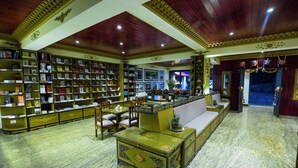 A library with bookshelves, a sofa, and a decorative chest. - Amritara Hidden Land, Gangtok (Gangtok)