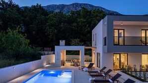 A modern two-story house with a swimming pool, outdoor seating, and a view of mountains. - Stylish property with heated 32sqm private pool, 3 bedrooms, 3 bathrooms, table tennis and table soccer (Gata)