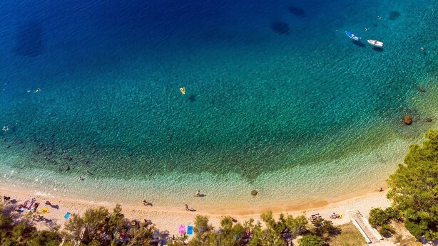 An aerial view of a beach with clear blue waters, a sandy shore, and a few boats. - Stylish property with heated 32sqm private pool, 3 bedrooms, 3 bathrooms, table tennis and table soccer (Gata)