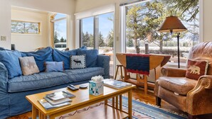A cozy living room with a blue sofa, a wooden coffee table, and a leather armchair.
