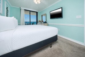 A hotel room with a large bed, a flat-screen TV, and a balcony with a view. - Phoenix East 509 2 Bedroom Condo (Orange Beach)