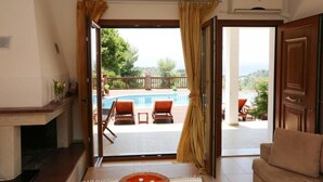 A room with a view of a swimming pool and outdoor seating. - Luxury Villa Nefeli w Private Pool (Skiathos)