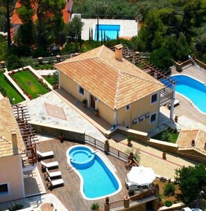A villa with a swimming pool, a covered patio, and a garden. - Luxury Villa Nefeli w Private Pool (Skiathos)